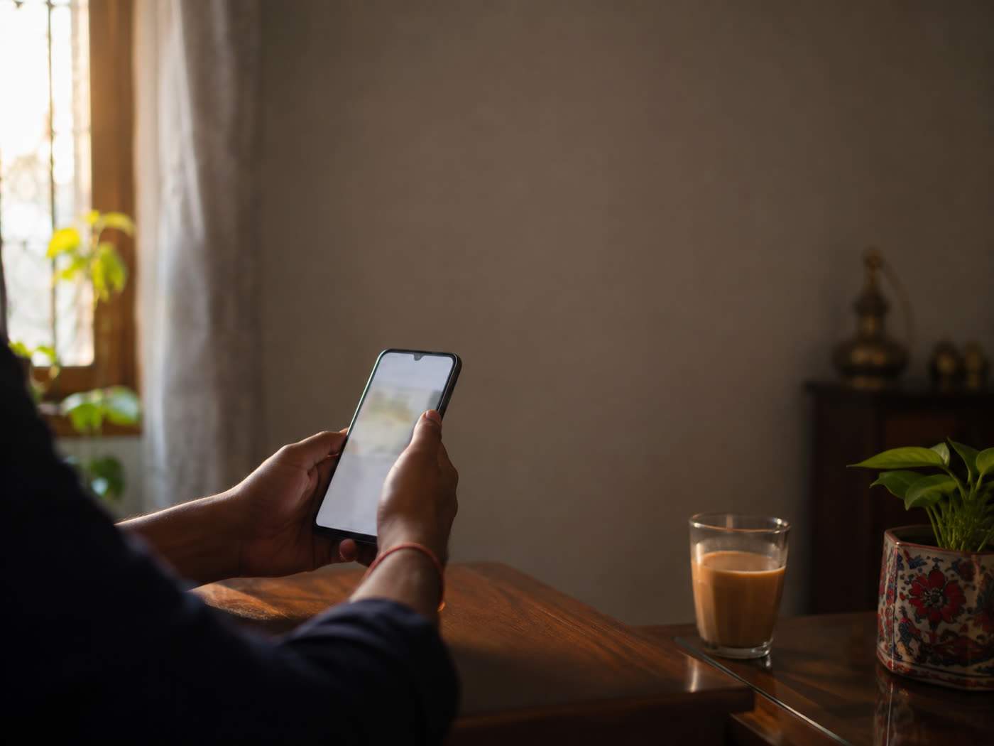 Someone answering Ezeal's questions on a phone at home, a glass of tea beside them